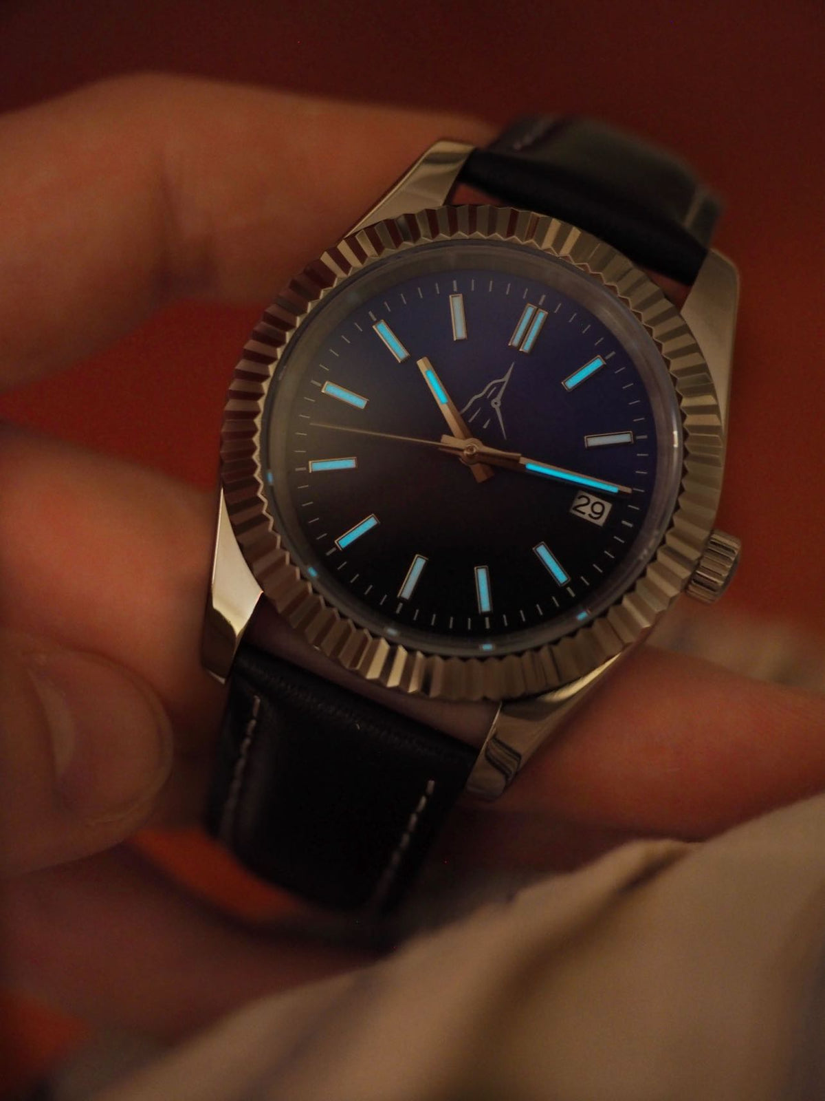Détail du Super-LumiNova bleu sur les index et les aiguilles de la montre automatique L'Horizon dans la pénombre