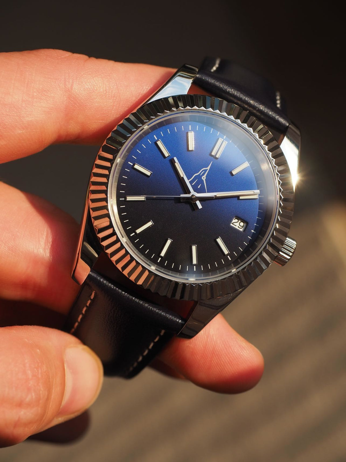 Montre automatique L'Horizon d'Aiguille d'Étretat avec cadran bleu soleillé et lunette cannelée en acier 316L au poignet